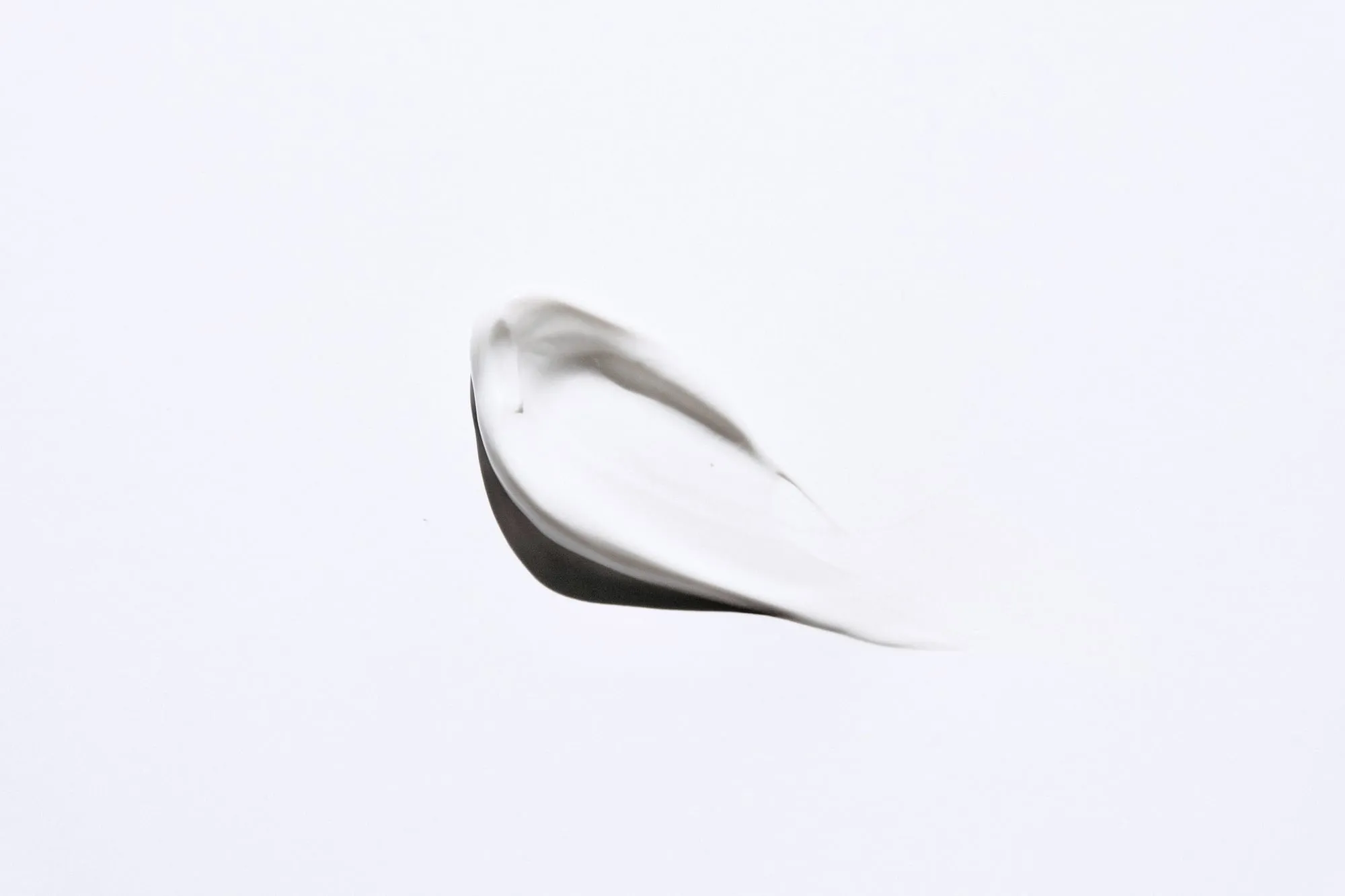 A single swipe of white cream on a pale grey surface